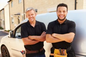 two-smiling-technicians-beside-a-work-van