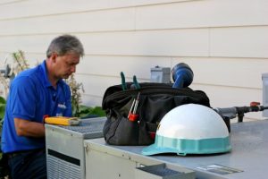 HVAC-technician-repairing-outdoor-AC-unit