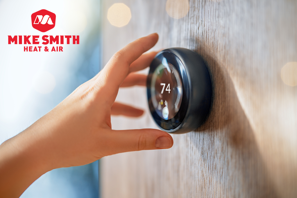 The hand reaching for a smart thermostat